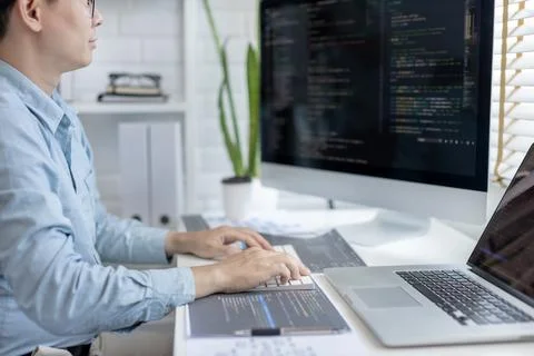 Professional development programmers are sit on a desk with work equipment su Stock-Fotos