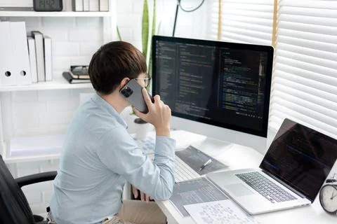 Professional development programmers are talking on the phone with their coll 스톡 사진
