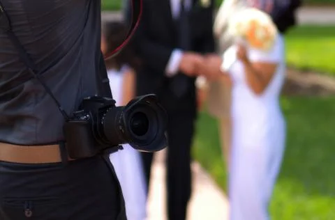 Professional digital camera hanging from a sweating photographers shoulder wh Stock Photos
