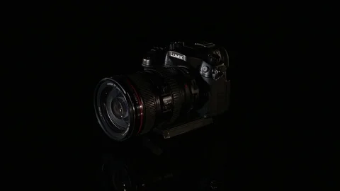 Professional digital photo camera rotate on black background Stock Footage 75669277