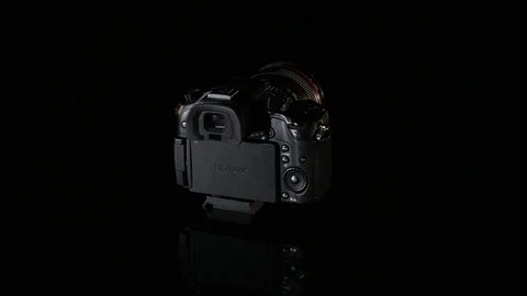 Professional digital photo camera rotate on black background Stock Footage 75670074