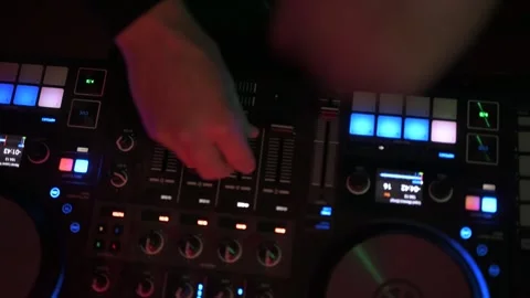 Professional disc jockey using a sound mixer console with adjusts faders, knobs, 스톡 동영상 327684528