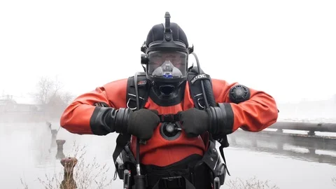 Professional diver in red diving equipment. Adjusts the belt that holds oxygen b Stock Footage 115794407