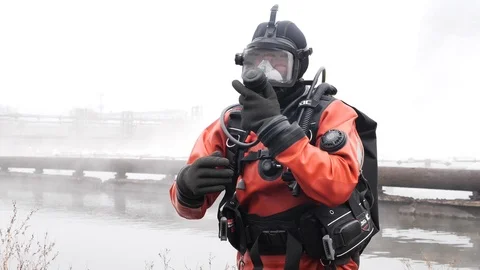 Professional diver in red diving equipment prepares to dive, checks oxygen suppl Stock Footage 115794475