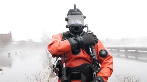 Professional Diver in red equipment for diving. Straightens the air hose Stock Footage 115794406