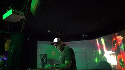 Professional dj performing a live techno set inside a modern club with green Stock Footage 331566080