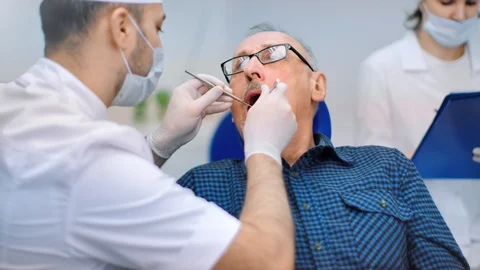 Professional doctor checking condition teeth of senior client dental clinic. 4k Stock Footage 127637785