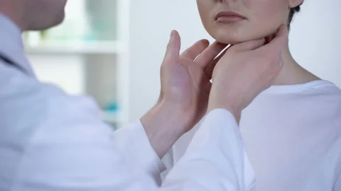Professional doctor checking patient neck and examining glands during flu Stock Footage 88285414