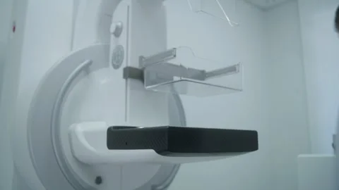 Professional doctor sets up digital mammogram scanning machine Stock Footage 251911134