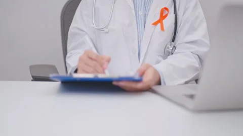 Professional doctor using laptop and writing notes for February World Cance.. Stock Footage 341382105