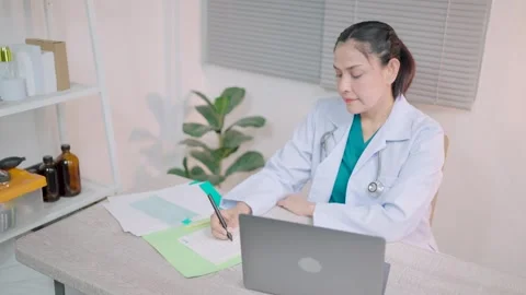Professional doctor writes notes in a notebook Working with a laptop on the tabl Stock Footage 264110719