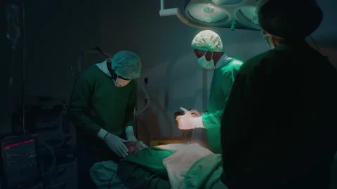 Professional doctors in the operating room making  CPR and use defibrillator  Stock Footage 195209725
