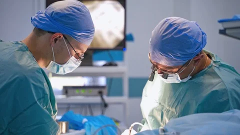 Professional doctors perform a surgery. Group of surgeons in medical uniform  Stock Footage 121708282