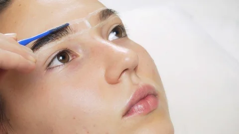 A professional does dyeing eyebrows with dyes, tinting. Video stock 121737298