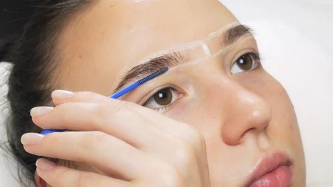 A professional does dyeing eyebrows with dyes, tinting. Video stock 121777678