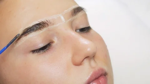 A professional does dyeing eyebrows with dyes, tinting. Vídeo Stock 121901553