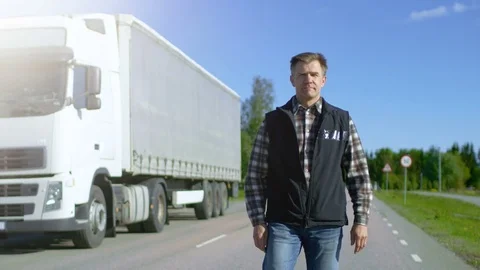 Professional Driver Gets out of the Parked White Semi Truck with Cargo Trailer Stock Footage 78748360