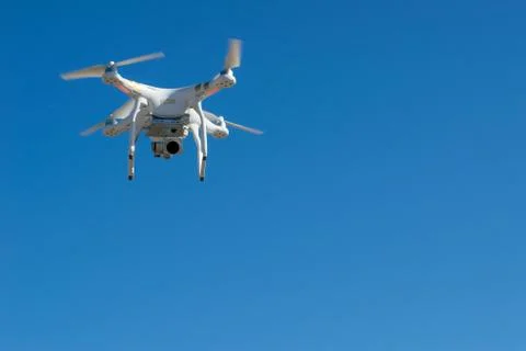 Professional drone with camera flying in blue sky Stock Photos