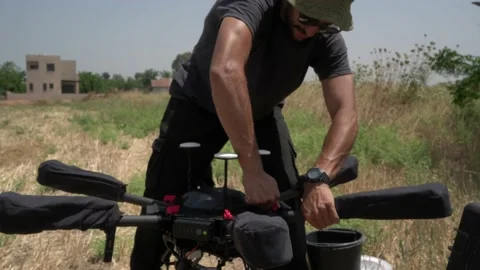 Professional drone pilot or stock photographer prepares a Drone for Flight. Stock Footage 139487243