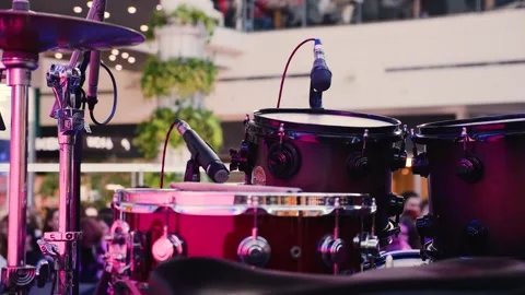 Professional drum kit and vocal microphones set up on an empty stage in a mall. Stock-Footage 329141272