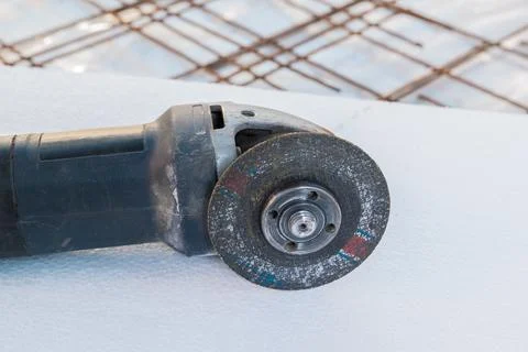 Professional electric angle grinder on a construction site Stock Photos