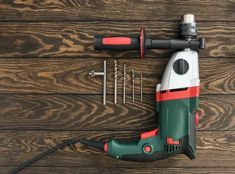 Professional electric drill and shatterproof drill  bits on wooden background Stock Photos
