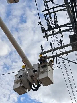 Professional electrical lineman worker technician in hydraulic bucket truck. Stock Photos