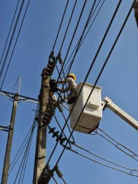 Professional electrical lineman worker technician in hydraulic bucket truck. Stock Photos