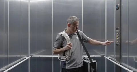 Professional electrician taking an elevator Stock Footage 308916254