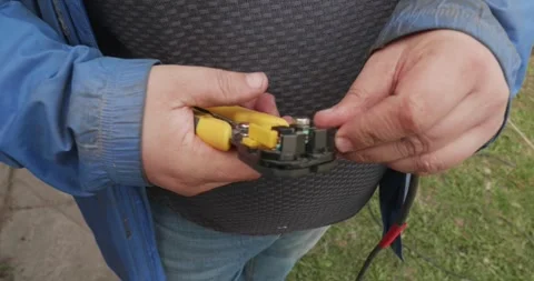 Professional electrician using a special tool to strip the insulation from a Stock Footage 334573960