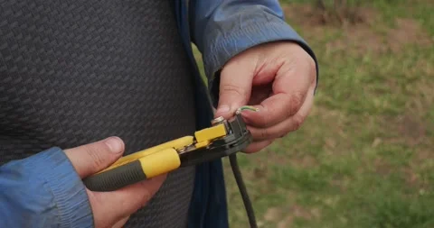 Professional electrician using a special tool to strip the insulation from a Stock Footage 335022029
