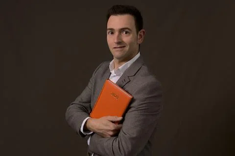 Professional Elegant formal self employed smiles and holds a 2023 orange agenda Stock Photos