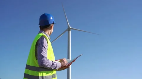 Professional engineer examining draft near wind turbine Stock Footage 144079153
