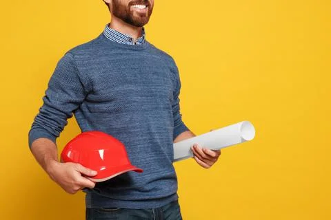 Professional engineer with hard hat and draft on yellow background, closeup Stock Photos