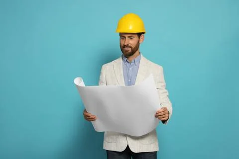 Professional engineer in hard hat with draft on light blue background Stock Photos