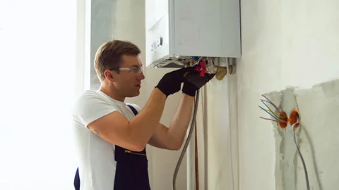 Professional engineer installing a natural gas boiler at home, he is checking Stock Footage 244669077