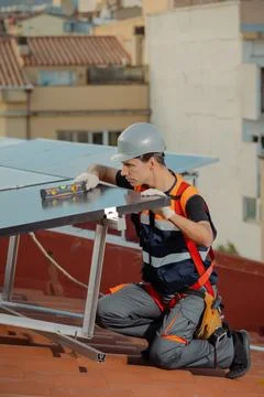 Professional engineer installing solar panels on the roof of a house Stock Photos