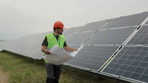 Professional engineer learning the design of the solar plant paper plan walks on Stock Footage 156812488