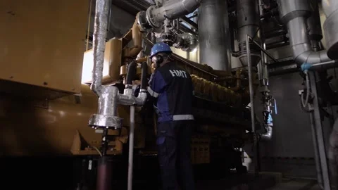 Professional engineer maintains a huge diesel unit in an industrial plant Stock Footage 212393995