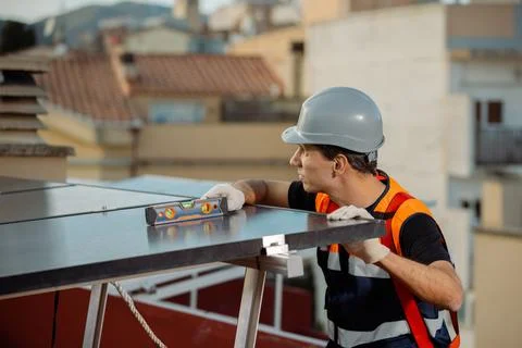 Professional engineer measuring solar panels on the roof of a house Stock Photos