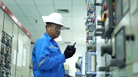 Professional engineer monitoring electrical control cabinets in a high-tech indu Video stock 347143953