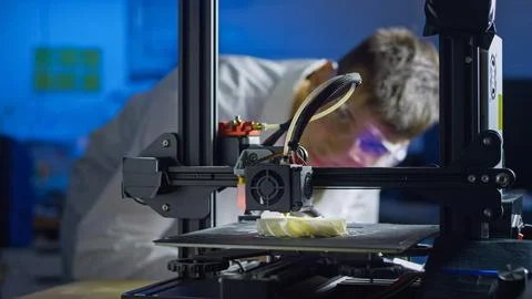Professional engineer monitors 3D printer in high tech laboratory setting Stock Photos