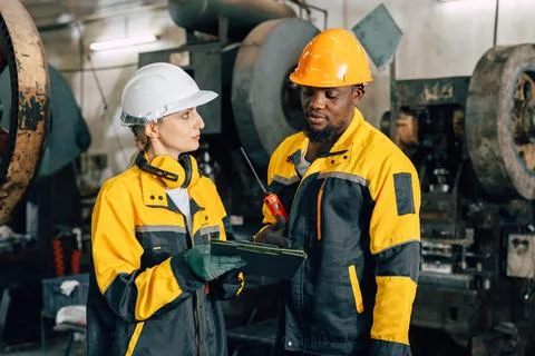 Professional engineer team inspecting service machine in heavy industry facto Foto stock