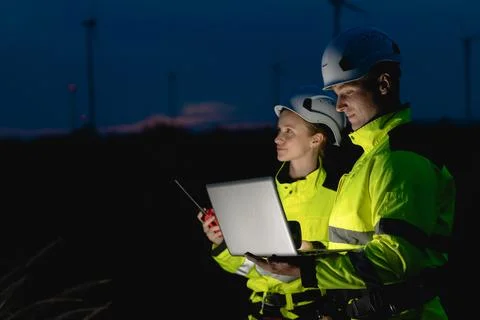 Professional engineer team at night shift. Workers in wind turbine. Technic.. Stock Photos