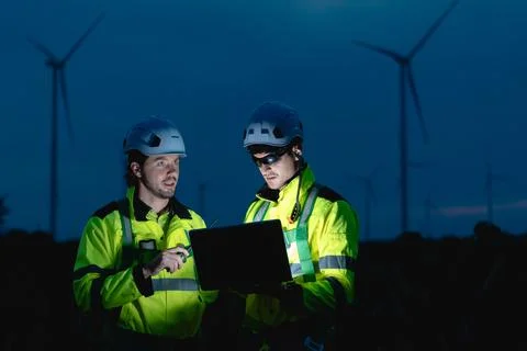 Professional engineer team at night shift. Workers in wind turbine. Technic.. Stock Photos