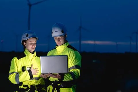 Professional engineer team at night shift. Workers in wind turbine. Technic.. Stock Photos