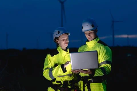 Professional engineer team at night shift. Workers in wind turbine. Technic.. Stock Photos