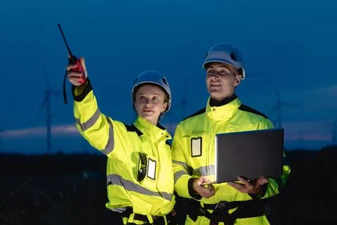 Professional engineer team at night shift. Workers in wind turbine. Technic.. Stock Photos