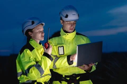 Professional engineer team at night shift. Workers in wind turbine. Technic.. Stock Photos