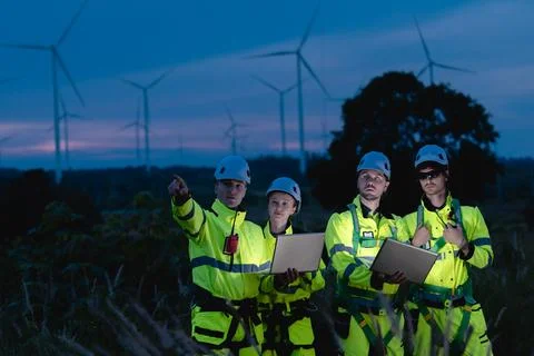 Professional engineer team at night shift. Workers in wind turbine. Technic.. Stock Photos
